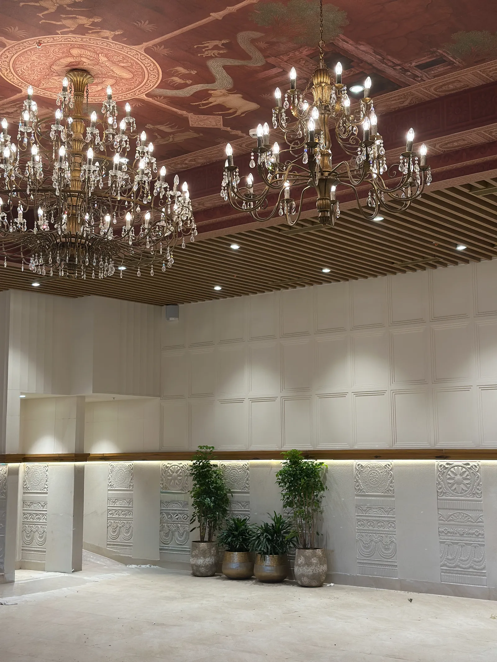 Banquet hall wall panelling with chandeliers above — Chalukya Samrat
